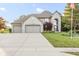 Beautiful two-story brick home with a three-car garage and well-manicured lawn on a sunny day at 2320 Whispering Way, Indianapolis, IN 46239