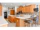 Spacious kitchen featuring wooden cabinets, tile backsplash, white countertops, and a large island with seating at 2320 Whispering Way, Indianapolis, IN 46239