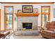 Cozy living room with a brick fireplace, natural light from surrounding windows, and hardwood trim at 2320 Whispering Way, Indianapolis, IN 46239