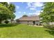 Expansive backyard featuring green grass, mature trees, patio area with outdoor seating, and privacy fencing at 31 Morningside Ct, Whiteland, IN 46184