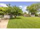 Large grassy backyard featuring mature trees, two storage sheds and chain link fencing at 31 Morningside Ct, Whiteland, IN 46184