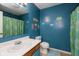 Colorful bathroom with bright blue walls and patterned shower curtain at 31 Morningside Ct, Whiteland, IN 46184