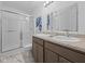 Bright bathroom featuring a double sink vanity, framed mirrors, and a glass-enclosed shower at 3142 Lennon Ln, Indianapolis, IN 46235