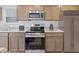 Close up on a kitchen featuring stainless steel appliances, wooden cabinets, and light countertops at 3142 Lennon Ln, Indianapolis, IN 46235