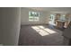 Bright and spacious living room featuring plush carpeting and large windows, seamlessly flowing into the kitchen at 3142 Lennon Ln, Indianapolis, IN 46235