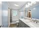 Bathroom featuring double sinks, grey vanity, and a white tiled shower/tub at 3504 White River Ct, Anderson, IN 46012