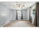 Bedroom with ceiling fan, gray walls, plush carpet and multiple windows with gray curtains at 3504 White River Ct, Anderson, IN 46012