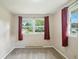 Bright bedroom with neutral walls, carpet, two large windows, and red curtains at 3504 White River Ct, Anderson, IN 46012
