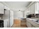 Bright kitchen with white cabinets, breakfast bar, and a view into the adjoining living space at 3504 White River Ct, Anderson, IN 46012