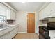 Well-lit kitchen with white cabinets, backsplash, ample counter space, and black appliances at 3504 White River Ct, Anderson, IN 46012