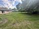 Spacious backyard featuring a large lawn, mature trees and a brick house at 4032 Roselawn Ave, Columbus, IN 47203