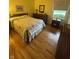 Bright bedroom with hardwood floors, a patterned quilt, and natural light at 4032 Roselawn Ave, Columbus, IN 47203