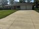 Charming ranch-style home featuring a well-manicured lawn, a long concrete driveway, and an attached two-car garage at 4032 Roselawn Ave, Columbus, IN 47203