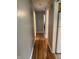Hallway with hardwood flooring and neutral paint, leading to various rooms at 4032 Roselawn Ave, Columbus, IN 47203