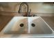 Close-up of the white double basin sink featuring a modern chrome faucet at 4032 Roselawn Ave, Columbus, IN 47203