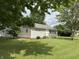Charming single-story home with a lush lawn, a small front porch, and mature trees providing shade at 411 N 18Th St, Noblesville, IN 46060