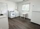 Well-lit kitchen featuring white appliances, hardwood style flooring, and a convenient laundry area at 411 N 18Th St, Noblesville, IN 46060