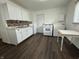 Functional kitchen featuring white appliances, tile backsplash, and hardwood-style flooring at 411 N 18Th St, Noblesville, IN 46060