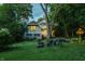 A tranquil backyard with a lush lawn, patio seating, and a beautiful home exterior at 4130 N Meridian St, Indianapolis, IN 46208