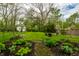 Lush backyard with manicured lawn, mature trees, a seating area, and landscaped flower beds at 4130 N Meridian St, Indianapolis, IN 46208