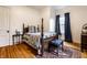 Bedroom features a four-poster bed, hardwood floors, and blue curtains at 4130 N Meridian St, Indianapolis, IN 46208