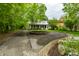 View of the house nestled amongst lush trees with a circular driveway and manicured landscaping at 4130 N Meridian St, Indianapolis, IN 46208