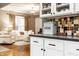 Kitchen featuring a decorative backsplash, a 'Bread' box, white cabinets, and a view of the living room at 4130 N Meridian St, Indianapolis, IN 46208