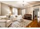 Living room with white sofas, piano, geometric rug, lots of natural light, and view to entry hall at 4130 N Meridian St, Indianapolis, IN 46208