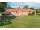 Backyard view of brick home featuring brick chimney and patio perfect for entertaining at 425 Saddle Hill Ct, Indianapolis, IN 46234