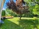 The backyard has a newly refinished wood deck and mature tree providing shade at 4536 Clayburn Dr, Indianapolis, IN 46268
