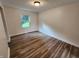 Serene bedroom features neutral paint, modern wood-look flooring, and a window for ample natural light at 4536 Clayburn Dr, Indianapolis, IN 46268