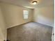 This cozy bedroom features neutral walls, plush gray carpeting, and a bright window to let in natural light at 4536 Clayburn Dr, Indianapolis, IN 46268