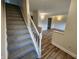 Inviting entryway with carpeted stairs and new wood-look flooring leading into a bright, freshly painted living space at 4536 Clayburn Dr, Indianapolis, IN 46268