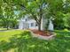 Two-story home with attached garage, featuring a blue door, shutters, and a beautifully landscaped yard at 4536 Clayburn Dr, Indianapolis, IN 46268