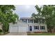 Two-story home with attached garage, featuring a blue door, shutters, and a well-manicured lawn at 4536 Clayburn Dr, Indianapolis, IN 46268