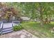A serene backyard featuring a gray deck, mature trees, and a play area at 5315 Rosslyn Ave, Indianapolis, IN 46220