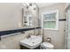 Bathroom featuring a toilet, sink, mirror, and window at 5315 Rosslyn Ave, Indianapolis, IN 46220