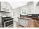 Charming kitchen with stainless steel stove, butcher block counters and bright white cabinets at 5315 Rosslyn Ave, Indianapolis, IN 46220