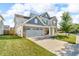 Beautiful two-story home with a well-kept lawn, brick accents, and a spacious driveway at 5353 Hibiscus Dr, Plainfield, IN 46168