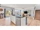 Open concept kitchen with granite island, stainless steel appliances, and seamless transition to the living area with staircase at 5353 Hibiscus Dr, Plainfield, IN 46168