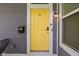 Close-up view of the home's charming yellow front door and exterior lighting at 630 Dorman St, Indianapolis, IN 46202
