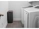 This laundry room features modern white appliances and neutral-toned tile flooring for efficient home management at 630 Dorman St, Indianapolis, IN 46202
