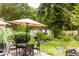 Charming backyard with patio set, shed with windowed doors, lush greenery, and mature trees at 6379 Monitor Dr, Indianapolis, IN 46220