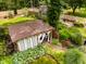 Aerial view of the landscaped backyard with an outbuilding, a cottage, and mature trees at 6379 Monitor Dr, Indianapolis, IN 46220