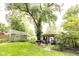 Lush backyard with mature trees, green lawn, and a cozy pergola at 6379 Monitor Dr, Indianapolis, IN 46220