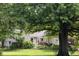 Well-manicured lawn and lush greenery adorn this charming beige home's front exterior at 6379 Monitor Dr, Indianapolis, IN 46220