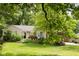 Charming home with a well-manicured front yard with mature trees and colorful flowerbeds at 6379 Monitor Dr, Indianapolis, IN 46220