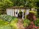 A close-up view of the charming outdoor gazebo surrounded by lush greenery and a stone pathway at 6379 Monitor Dr, Indianapolis, IN 46220