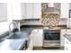 Kitchen featuring stainless steel appliances, modern backsplash, sink, and ample storage at 6379 Monitor Dr, Indianapolis, IN 46220