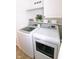 Well-organized laundry room with geometric wallpaper, white cabinets and shelves, and modern washer and dryer at 6379 Monitor Dr, Indianapolis, IN 46220